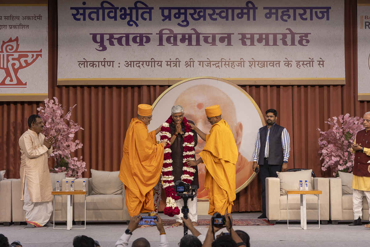Bhadreshdas Swami and Dharmatilak Swami honor Shri Gajendra Singh Shekhawat with a garland