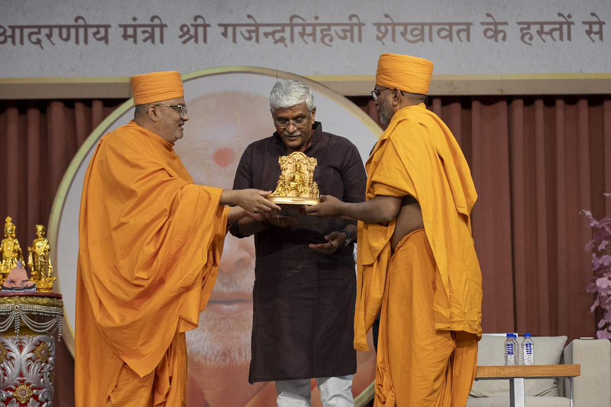 Bhadreshdas Swami and Dharmatilak Swami present a memento to Shri Gajendra Singh Shekhawat