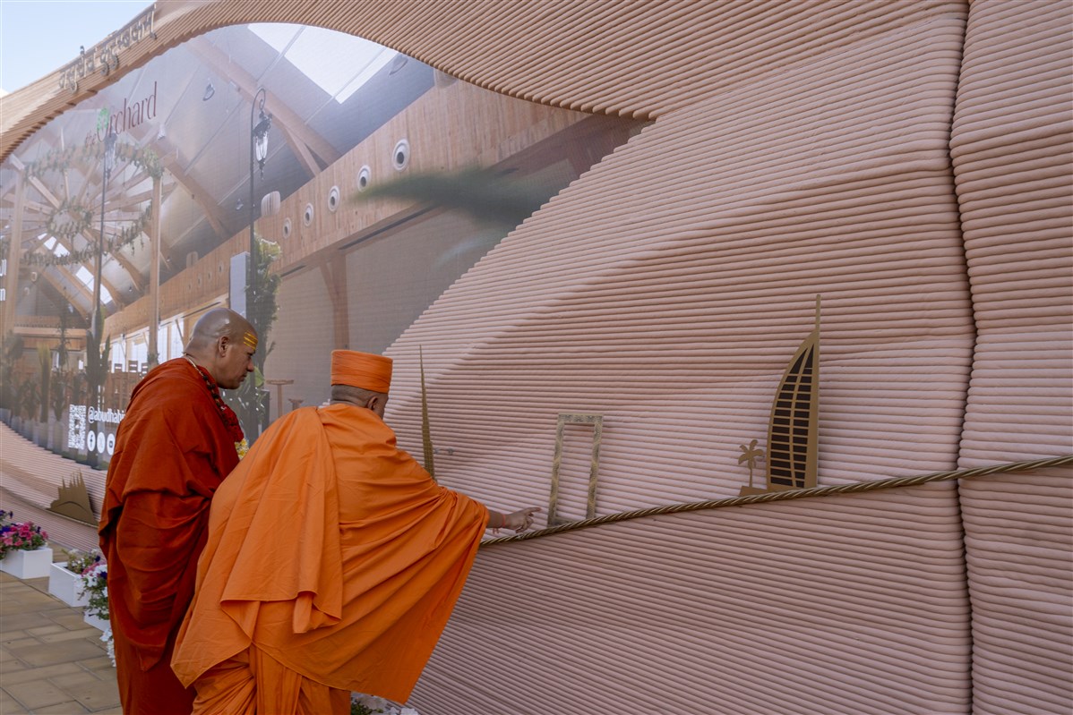 Swami Brahmaviharidas and Swami Kailashanand Giri Ji Maharaj closely observe the Wall of Harmony - one of the UAE’s largest 3D-printed structures