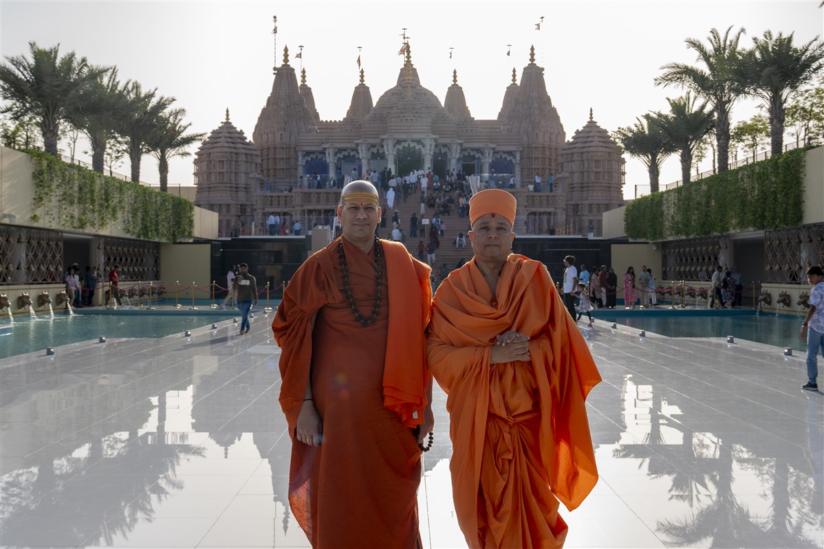 Swami Brahmaviharidas and Swami Kailashanand Giri Ji Maharaj in front of the majestic BAPS Hindu Mandir, Abu Dhabi
