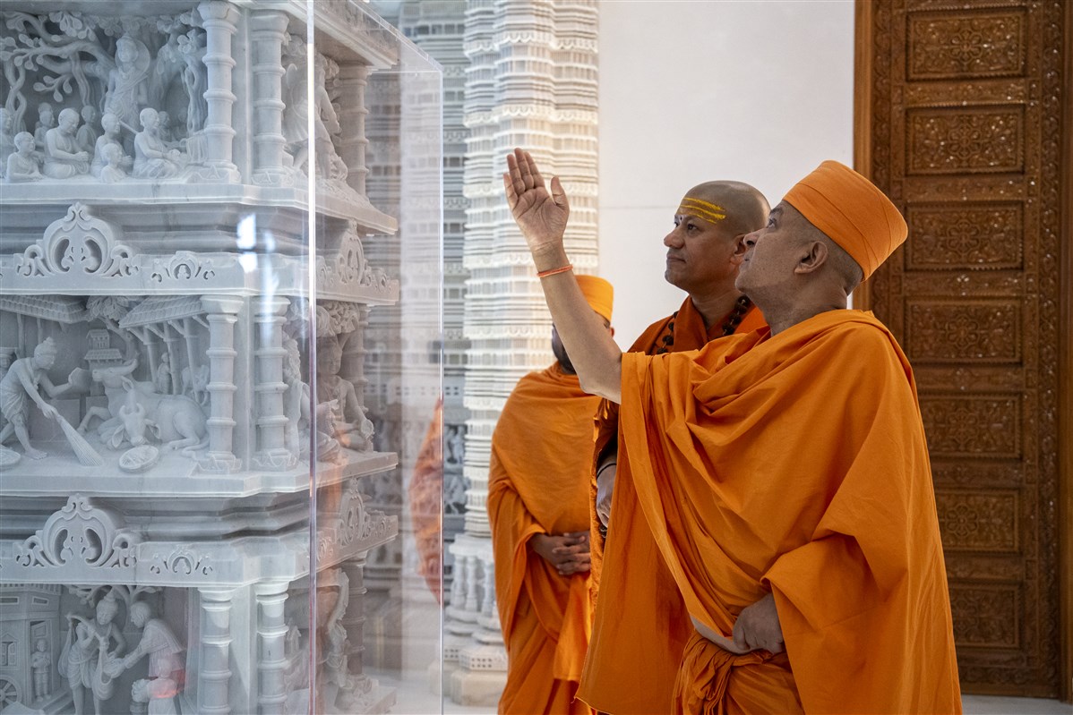 Swami Kailashanand Giri Ji Maharaj admires the detailed marble carvings depicting the divine life of Bhagwan Swaminarayan