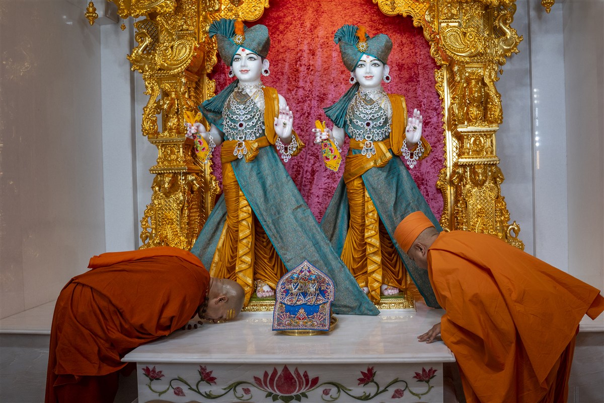 Swami Brahmaviharidas and Swami Kailashanand Giri Ji Maharaj bow down before Shri Akshar-Purushottam Maharaj in the Mandir’s inner sanctum