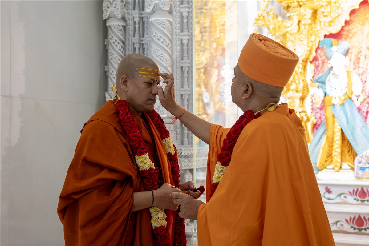 Swami Brahmaviharidas applies a chandlo to Swami Kailashanand Giri Ji Maharaj