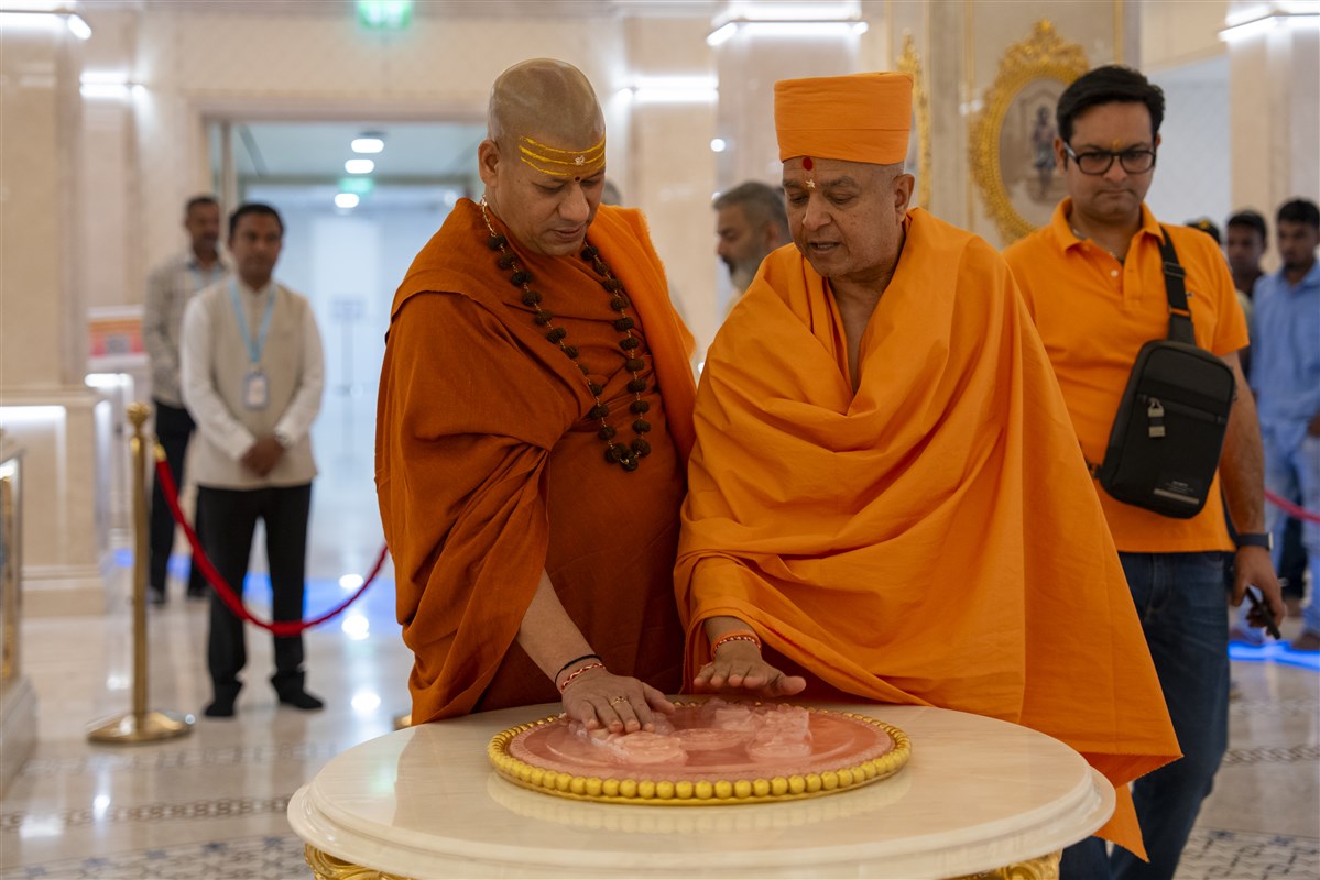 Swami Brahmaviharidas and Swami Kailashanand Giri Ji Maharaj offer their respects at the holy feet of Bhagwan Swaminarayan in the Abhishek Mandap