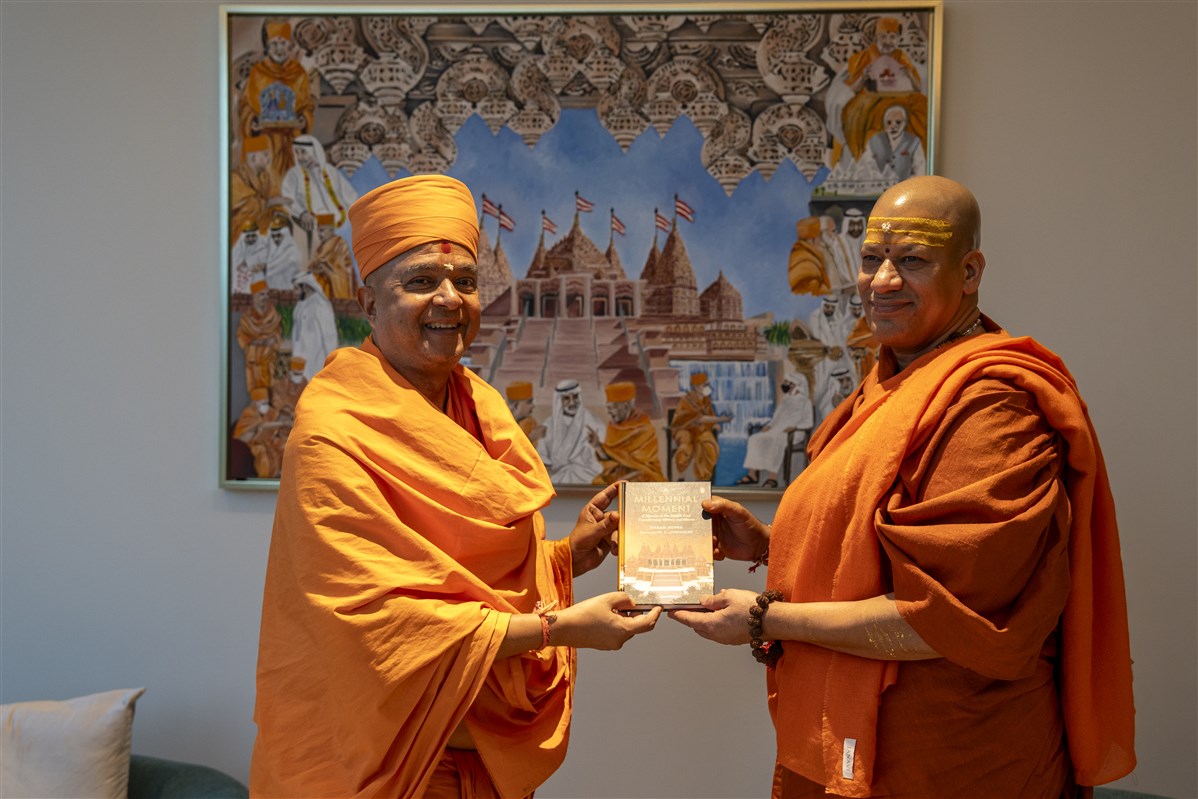 Swami Brahmaviharidas presents a copy of “A Millennial Moment: A Mandir in the Middle East Transforming History and Hearts” to Swami Kailashanand Giri Ji Maharaj