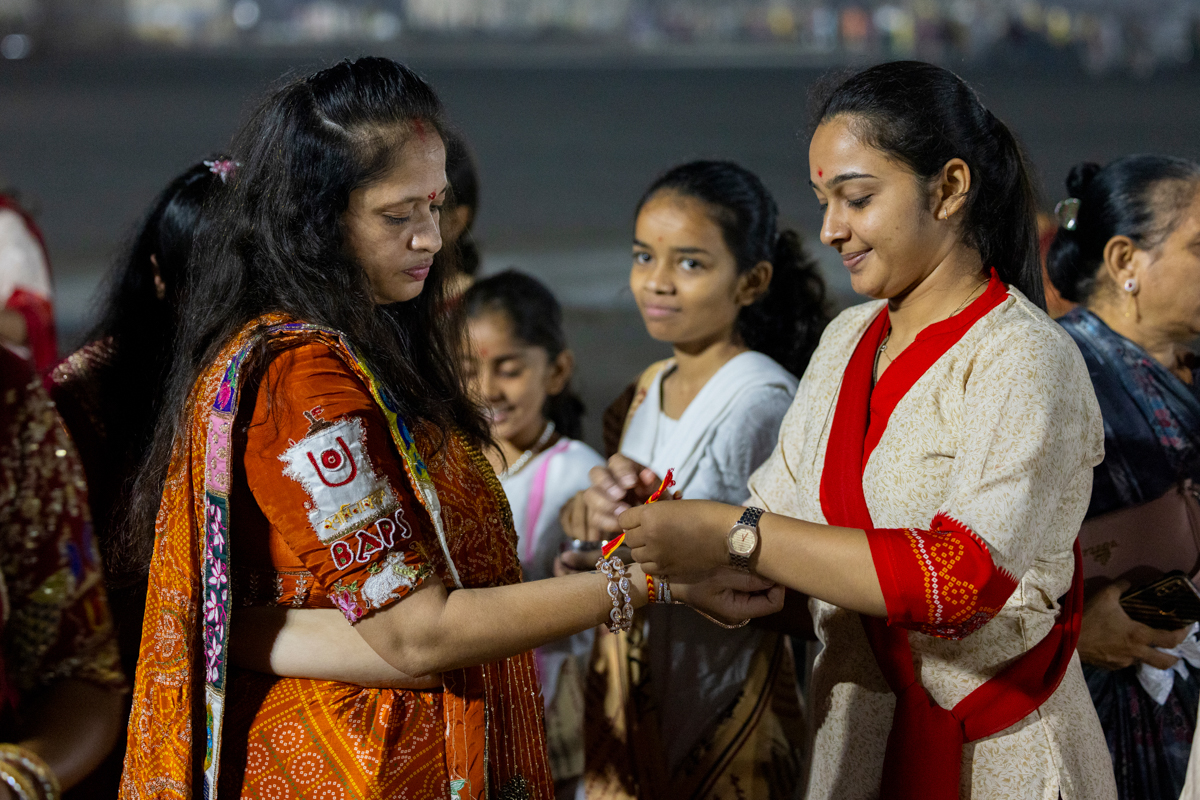 A karyakar ties a nadachhadi to a devotee