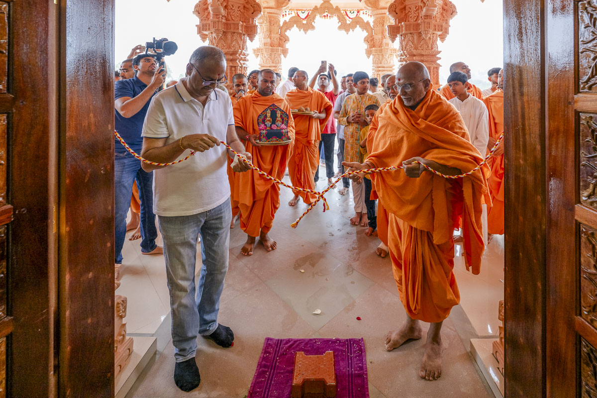Yagneshwar Swami and a dignitary perform the prasad pravesh rituals
