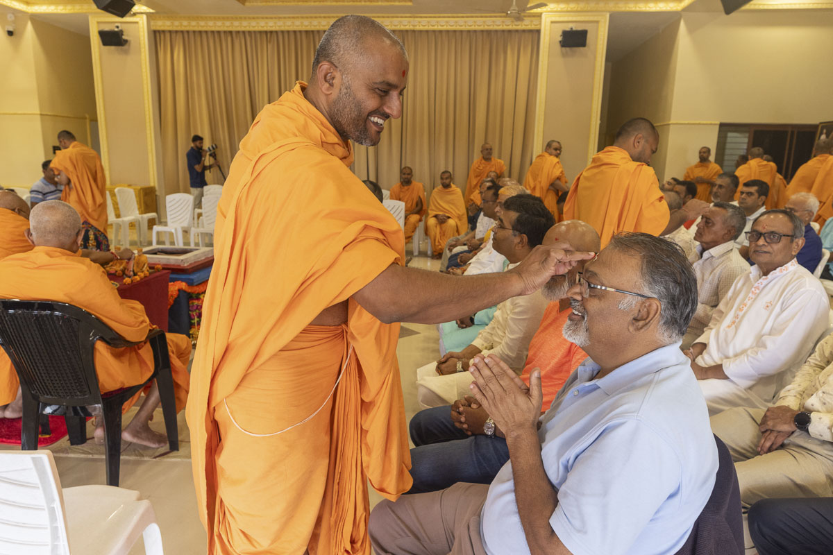A swami applies a chandlo to a devotee
