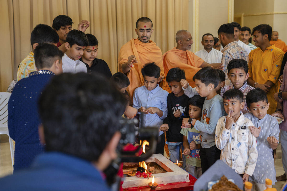 Children perform the yagna rituals