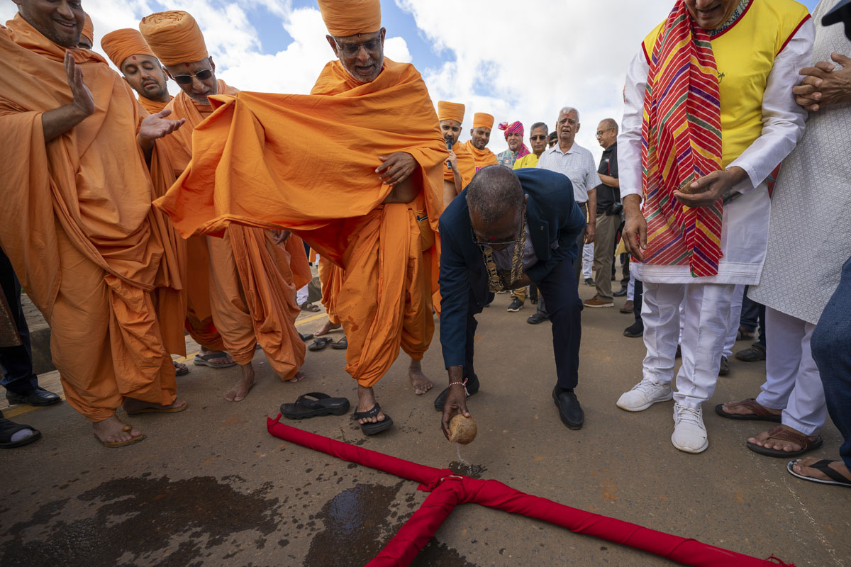 A dignitary splits a coconut before the nagar yatra