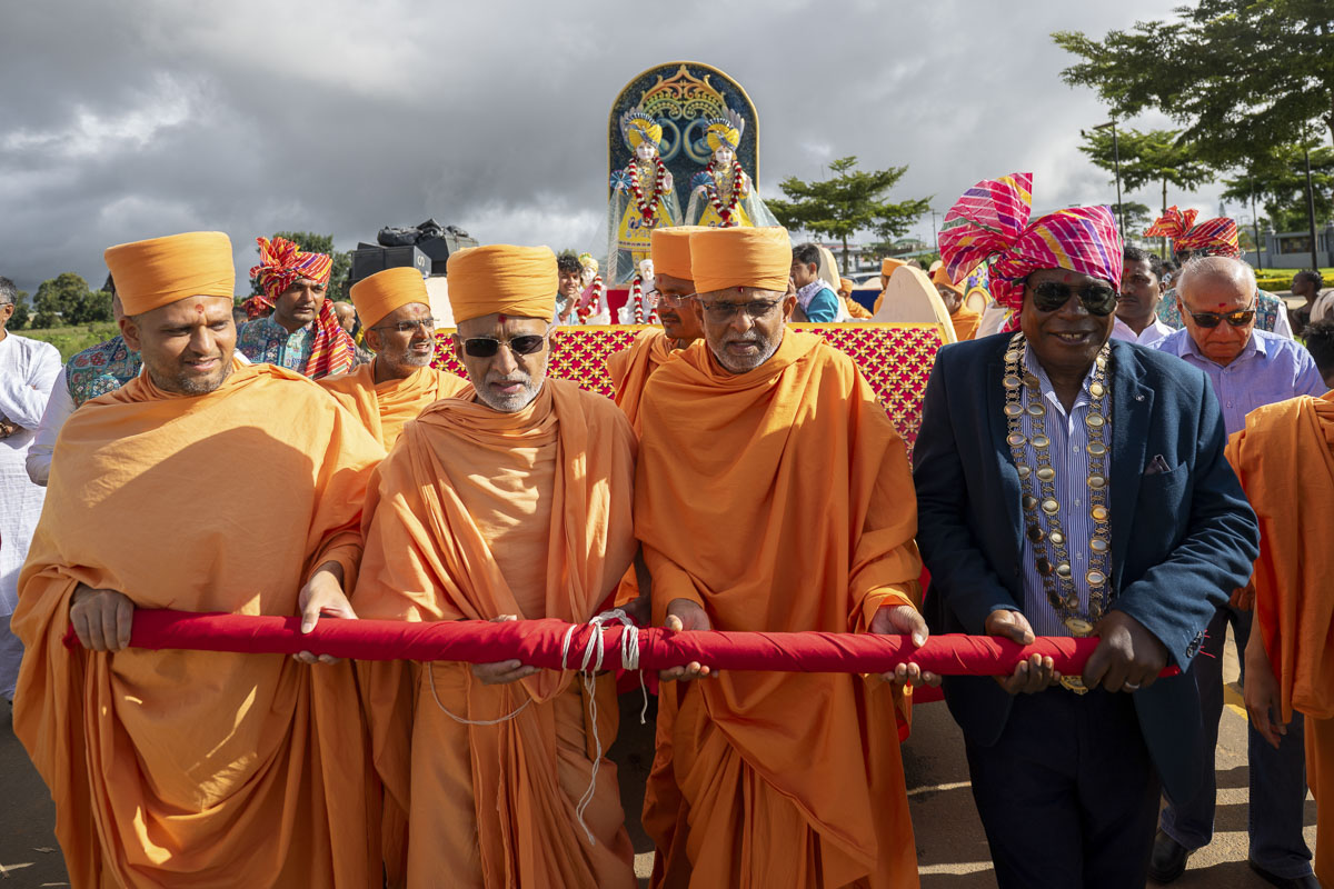 A dignitary and swamis pull the rath of Bhagwan Swaminarayan and Aksharbrahma Gunatitanand Swami