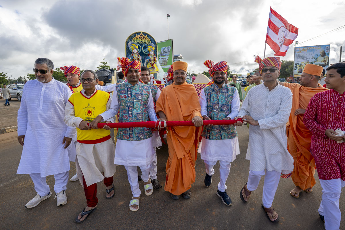 A swami and devotees pull the rath of Bhagwan Swaminarayan and Aksharbrahma Gunatitanand Swami