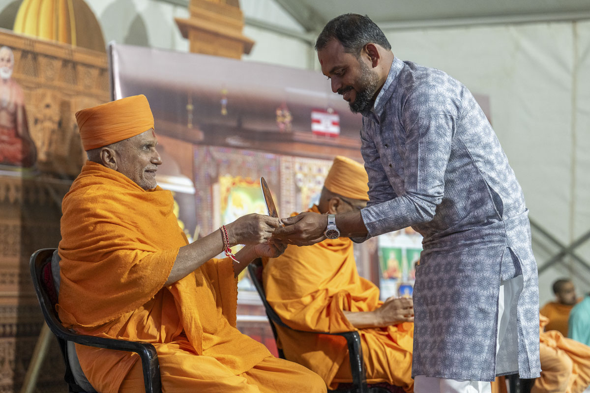 Yagneshwar Swami presents a memento to a devotee