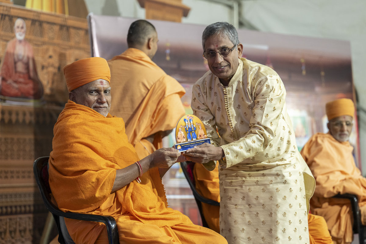 Yagneshwar Swami presents a memento to a devotee