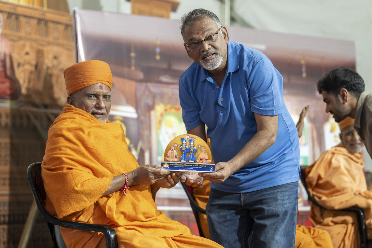 Yagneshwar Swami presents a memento to a devotee