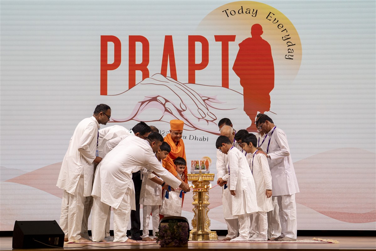 Swami Brahmaviharidas and the devotees light the traditional lamp