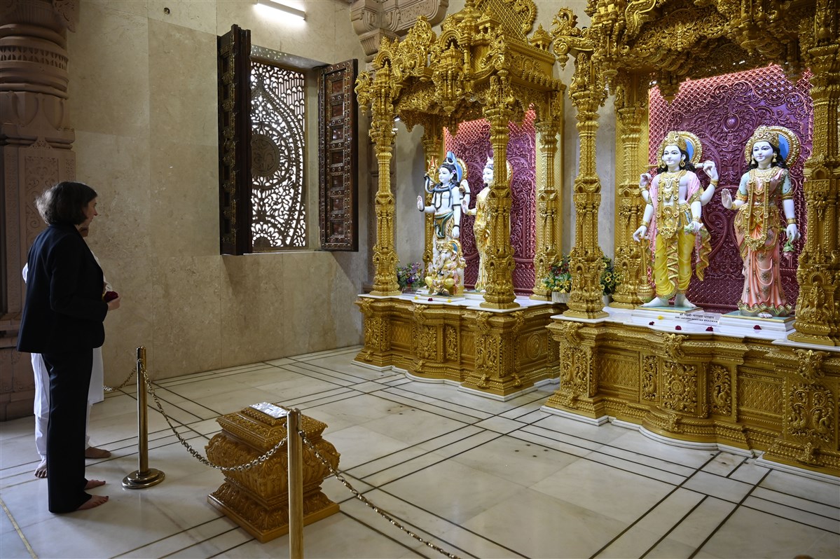Lindy Cameron prays before Bhagwan Shri Shankar, Shri Parvatiji and Bhagwan Lakshmi-Narayan