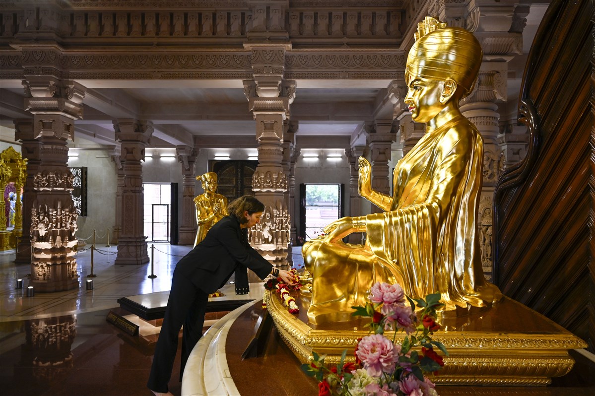 Lindy Cameron, British High Commissioner to India, offers flower petals to Bhagwan Swaminarayan