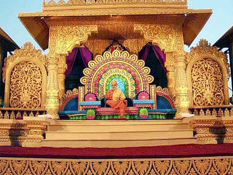 Swamishri seated on a resplendent stage, serenely chanting the holy name of Swaminarayan