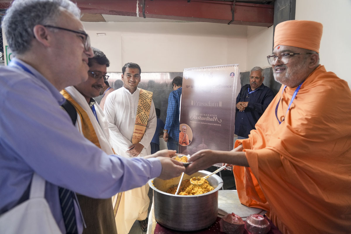 Bhadresh Swami serves sanctified Swaminarayan Khichadi prasad to renowned Sanskrit scholars from across the globe