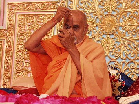 Performing tilak chandlo and chanting the name of Swaminarayan during his morning puja