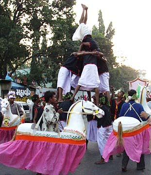 Exciting human pyramids during the procession by youth dancers, sadhus and tribal youths 