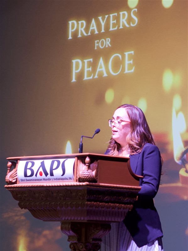 Rev. Erin Hougland, Executive Director of the Center for Interfaith Cooperation, addresses attendees at the prayer assembly, emphasizing that love and compassion shine brighter than hate.