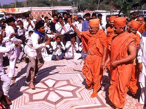 Tribal youth welcoming Swamishri with traditional music and dance