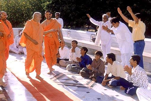 Swamishri responds to a jubiliant welcome by a few devotees while circumambulating the Smruti Mandir 