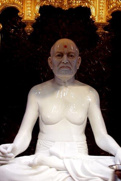 Abhishek of panchamrut and saffron water on the murtis of Shastriji Maharaj and Pramukh Swami Maharaj