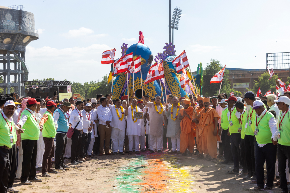 Dignitaries wave BAPS flags