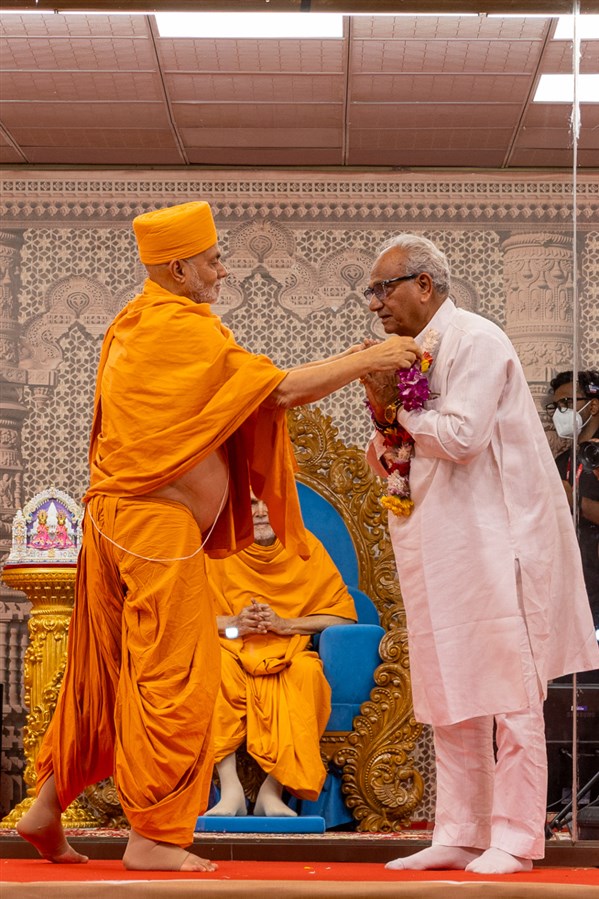 Pujya Viveksagar Swami honors a dignitary with a garland