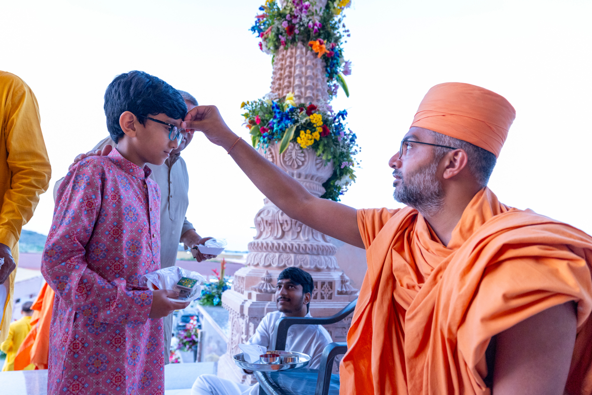 A swami applies a chandlo to a devotee