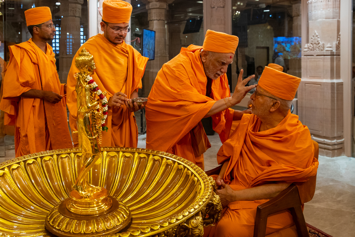 Atmaswarup Swami applies chandlo to Pujya Ghanshyamcharan Swami