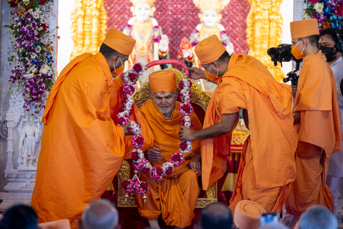 Swamis honor Swamishri with a garland