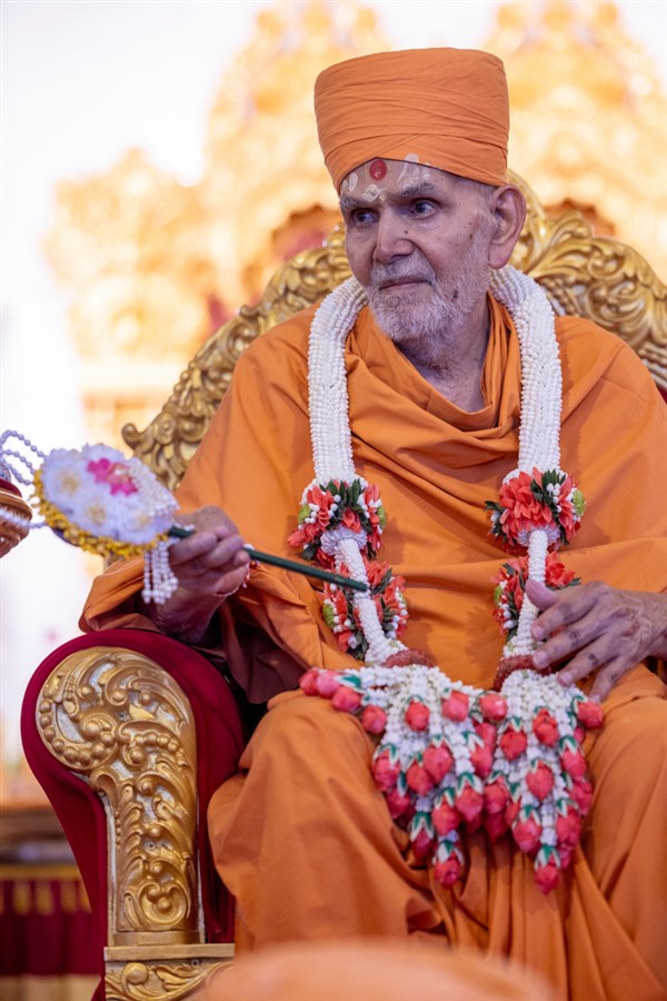Swamishri honored with a garland and a chhadi