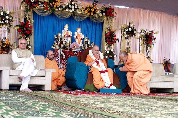 Swamishri is honored with a garland by Pujya Mahant Swami