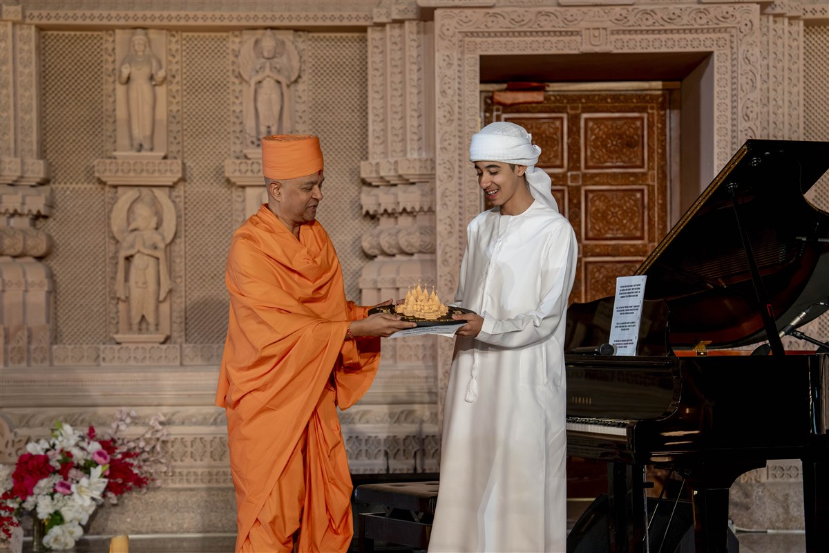 To honor Ahmed’s determination and the inspiration he brings to many, Swami Brahmaviharidas presented him with a special memento, a model of the Mandir surrounded by musical notes.