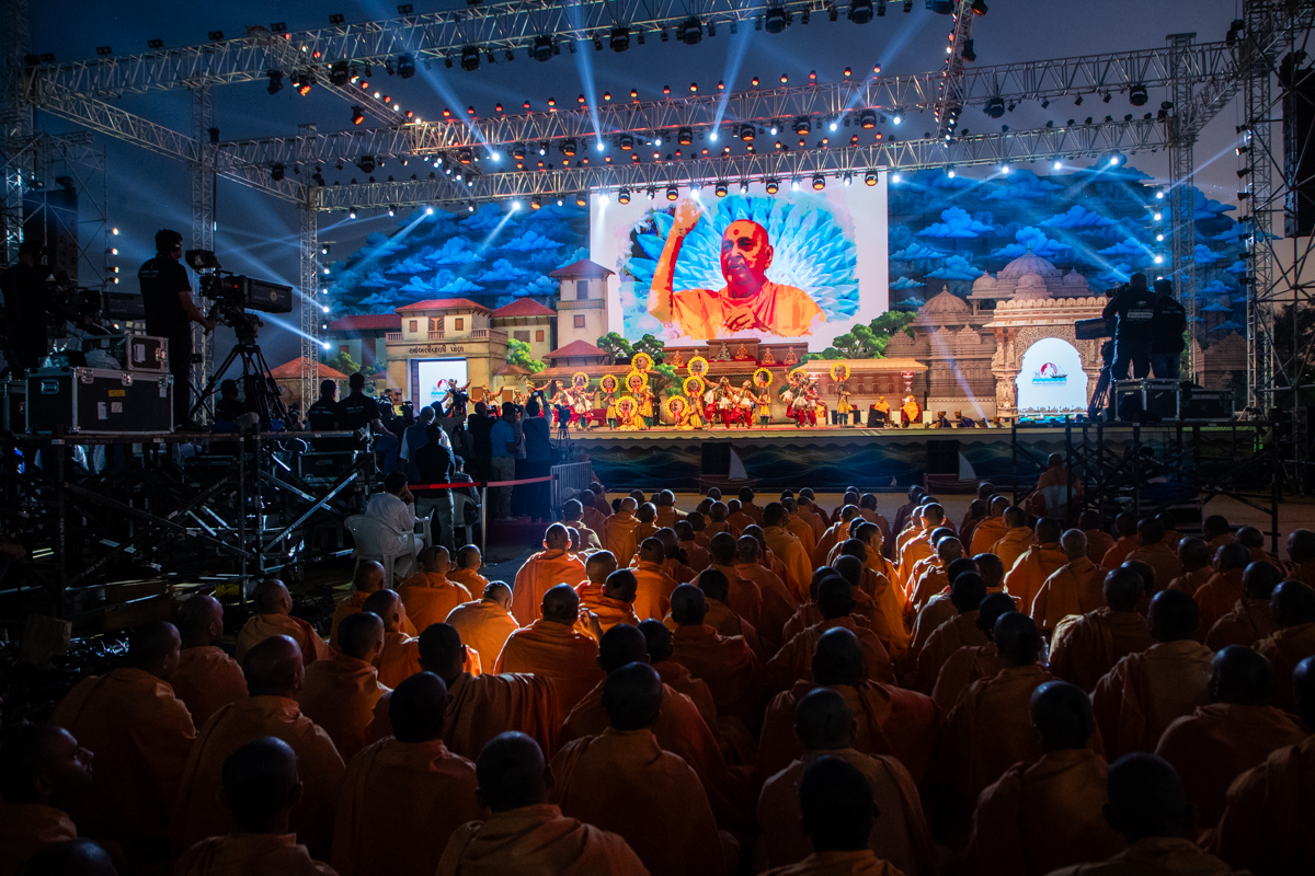 Swamis and devotees watch the performance