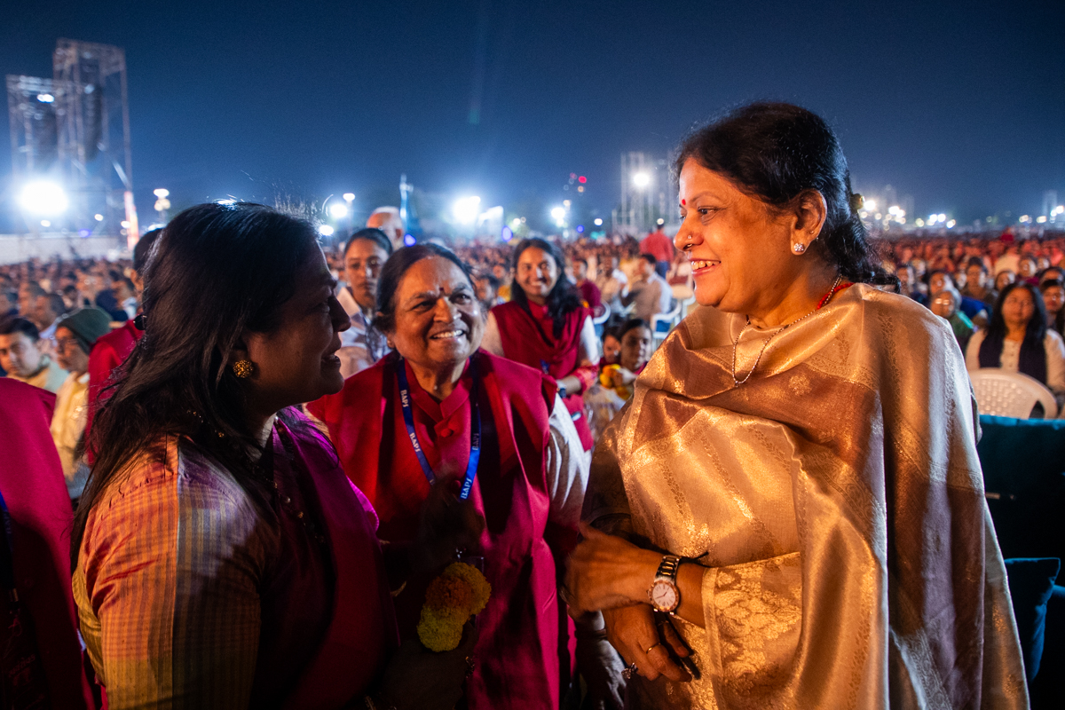 A karyakar honors Shrimati Sonalben Shah with a garland