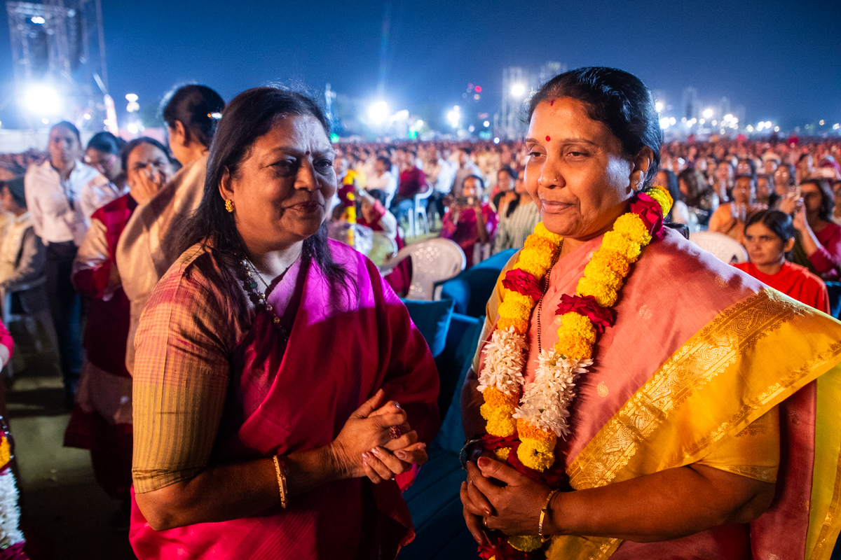 A karyakar honors Shrimati Pratibha Jain, Mayor of Ahmedabad, with a garland