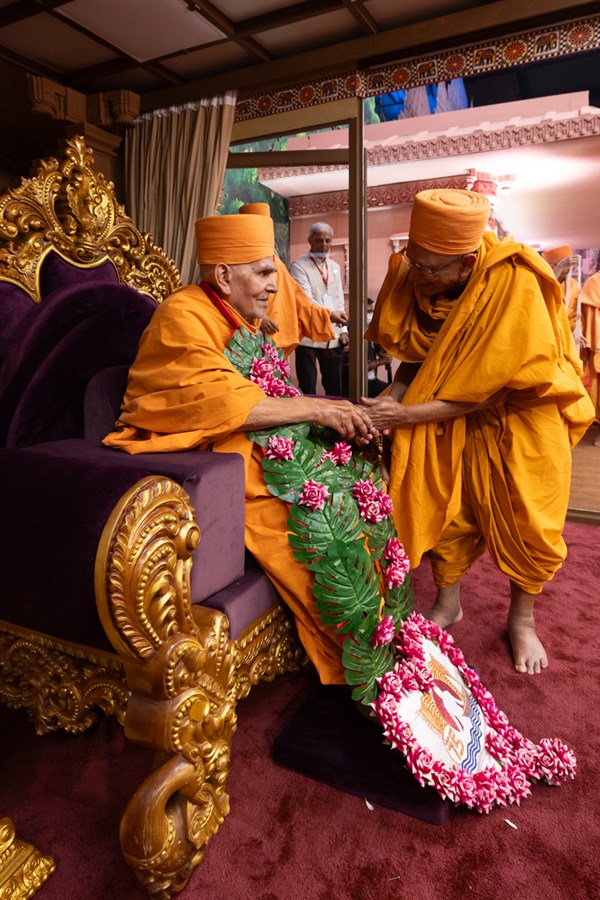 Pujya Tyagvallabh Swami honors Swamishri with a garland