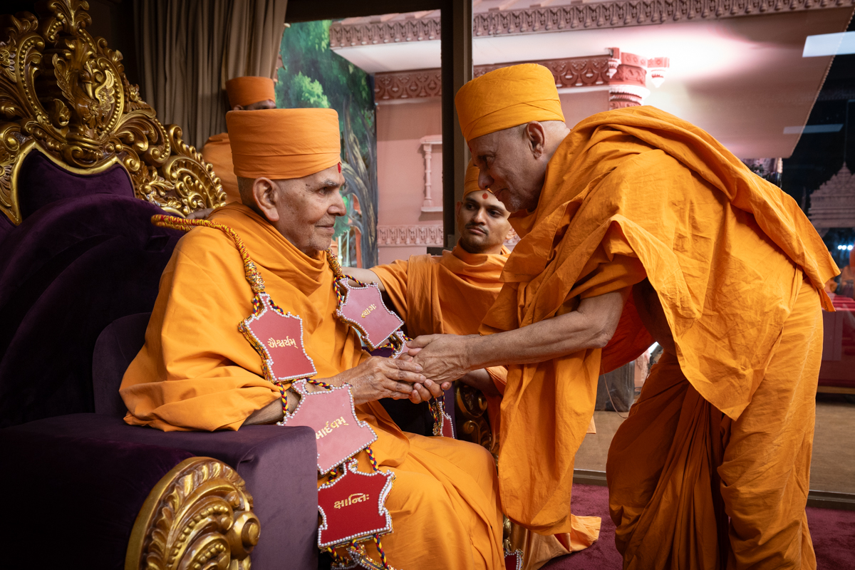 Pujya Viveksagar Swami honors Swamishri with a garland