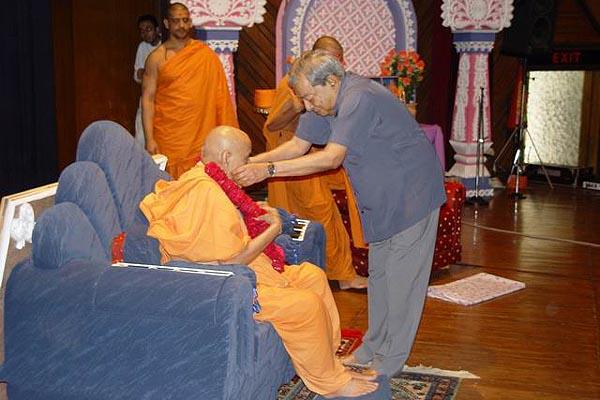 Dr. Kurien welcomes Swamishri with a garlands