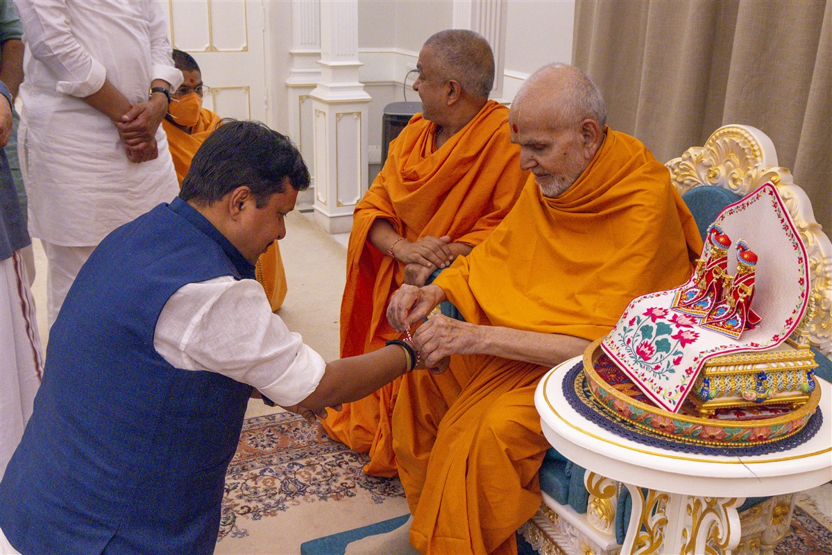 Swamishri ties a nadachhadi to Shri Nitin Navin
