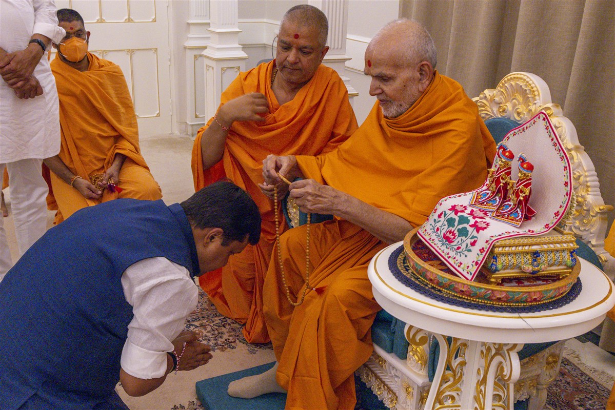 Swamishri blesses with a mala to Shri Nitin Navin