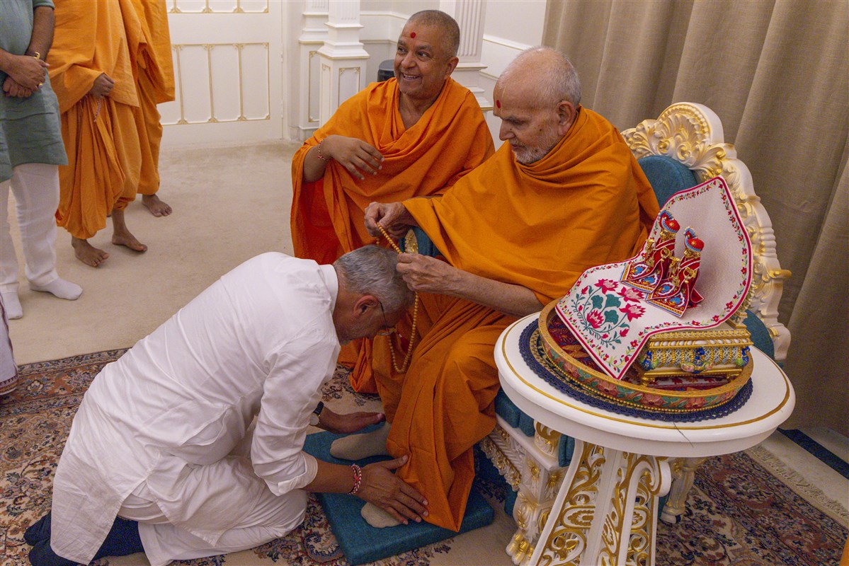 Swamishri blesses with a mala to Shri Jagdish Vishwakarma