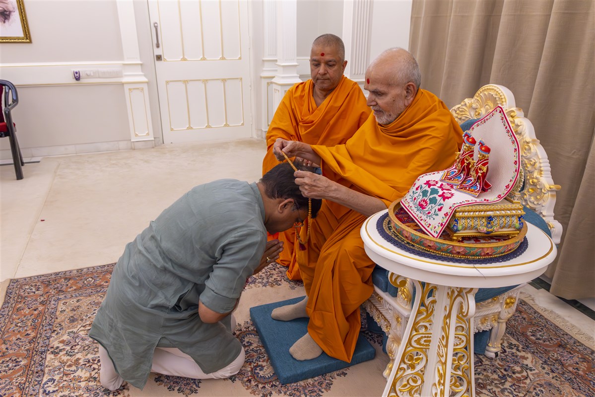 Swamishri blesses with a mala to Shri Ratnakarji
