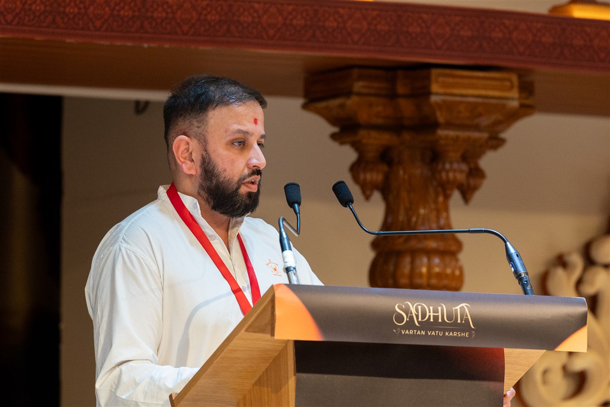 A yuvak explained the symbolism of the kesar offered to Mahant Swami Maharaj