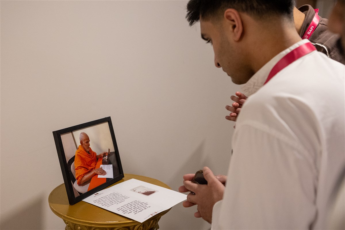 Delegates view the sanctified kesar offered to Mahant Swami Maharaj